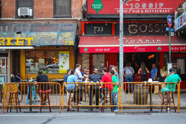A bar offers outdoor seating on the sidewalk